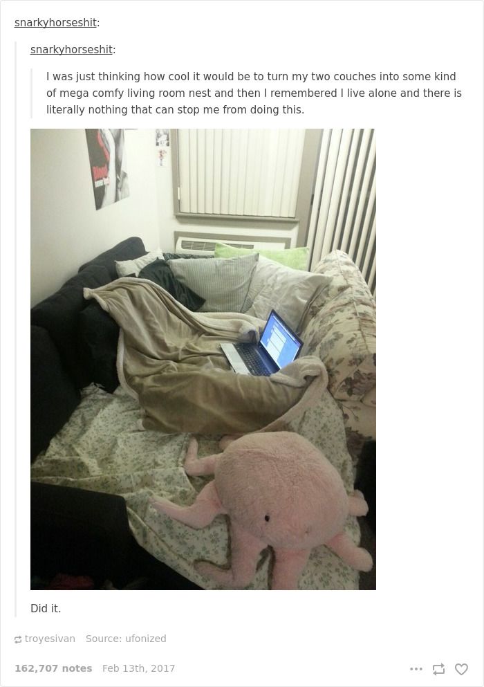 an elephant laying on top of a bed next to a pink stuffed animal in front of a laptop computer