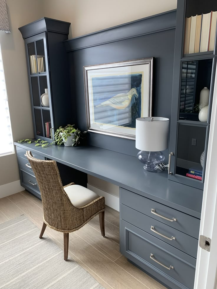 a desk with a chair, bookshelf and pictures on it