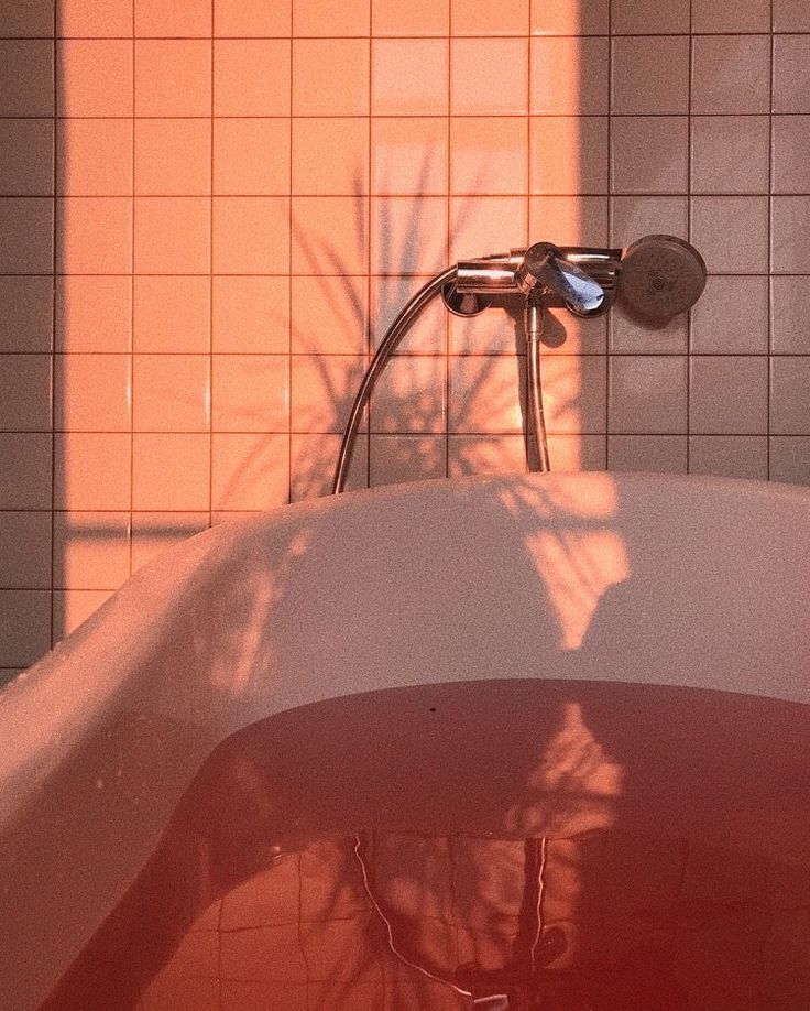 a bathtub in the middle of a bathroom with tile on the walls and floor