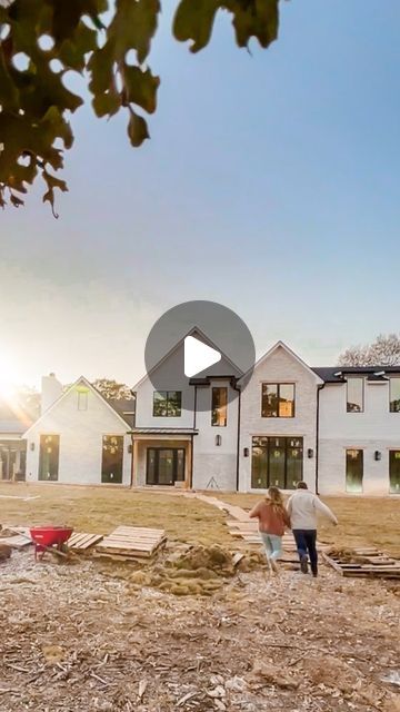 two people standing in front of a house under construction with the sun shining on them