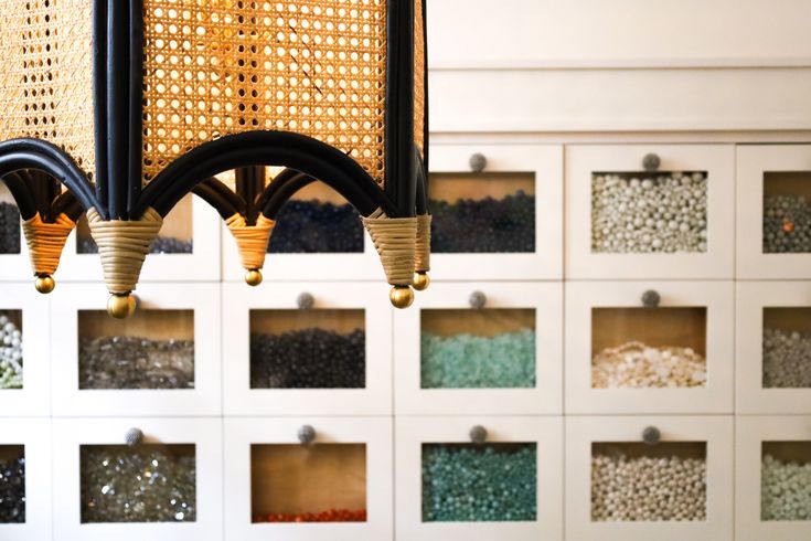 a chandelier hanging from the ceiling in front of a wall with many different colored beads