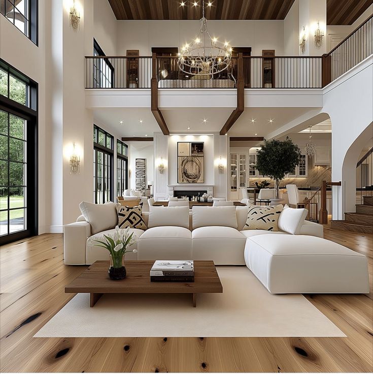 a living room filled with white furniture and lots of windows on top of wooden floors