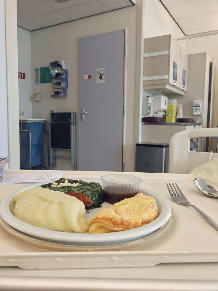 a white plate topped with food next to a fork and knife on top of a table