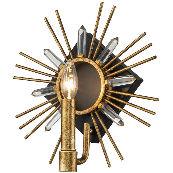 a gold and black wall light with a bulb on it's side, in the shape of a sunburst