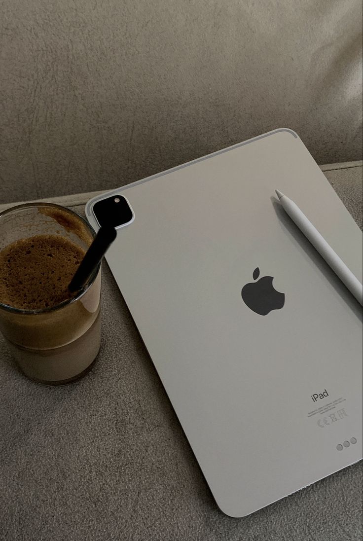 an apple ipad and a cup of coffee are on the table next to each other