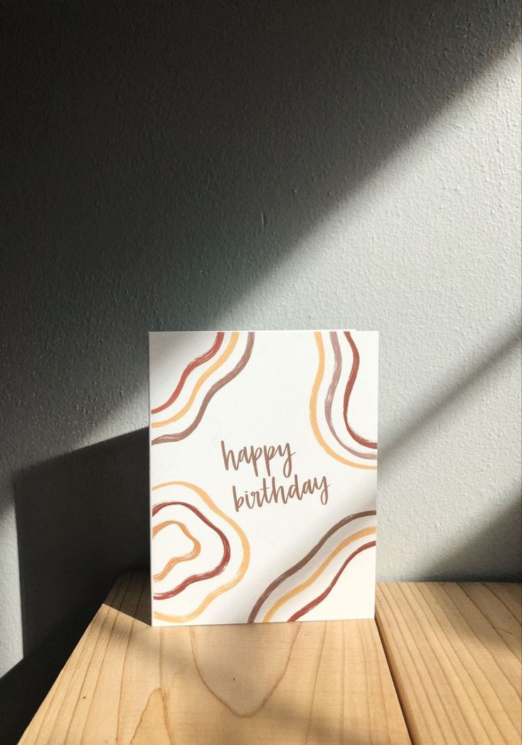 a happy birthday card sitting on top of a wooden table