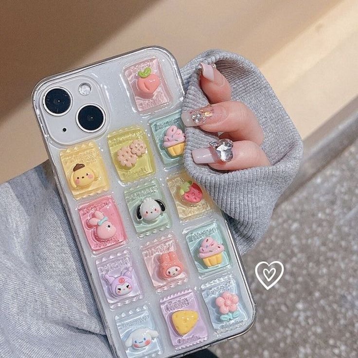 a person holding a cell phone case with various stickers on it