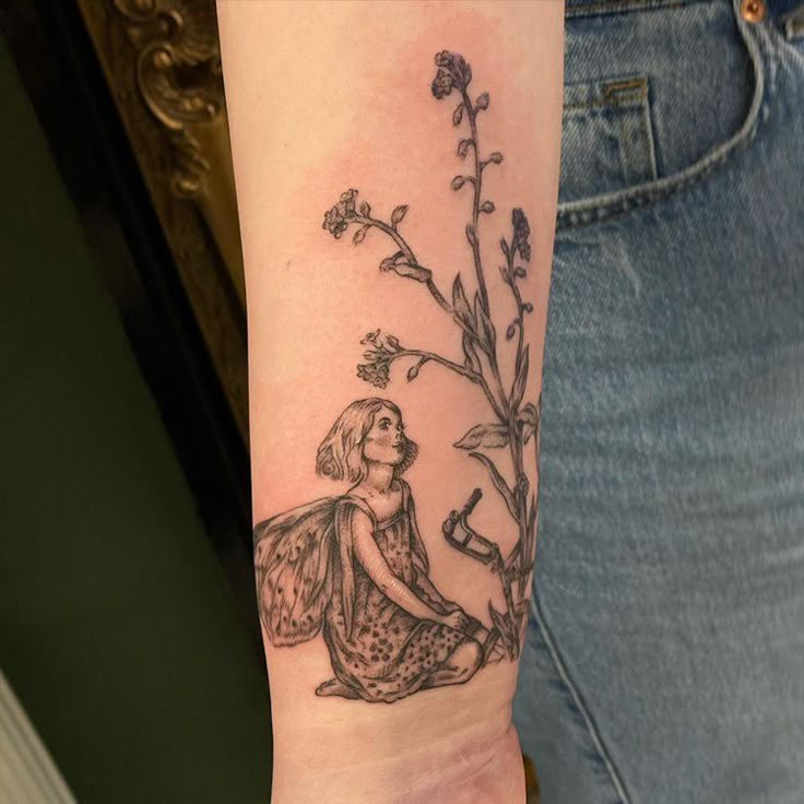 a woman's arm with a tattoo on it that has a flower and a fairy sitting next to a tree