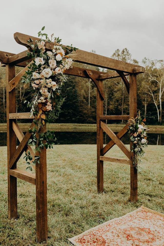 an outdoor ceremony setup with flowers and greenery