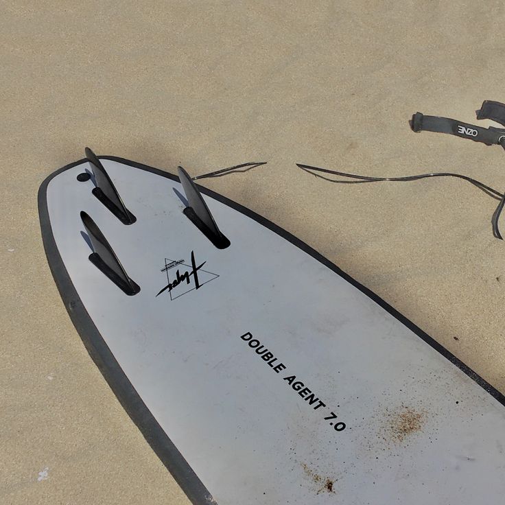 an upside down surfboard laying on the sand