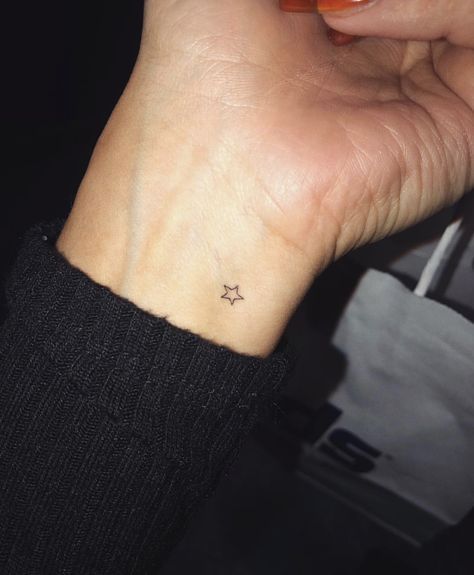 a small star tattoo on the wrist