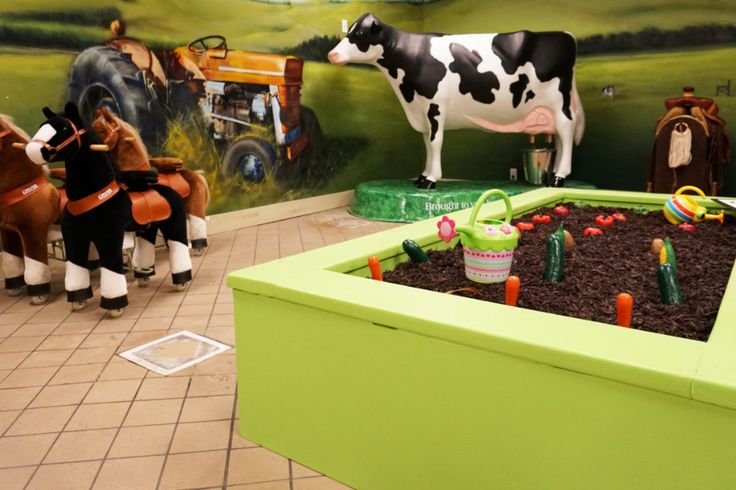 toy farm animals and toys are on display in the children's play area at the museum