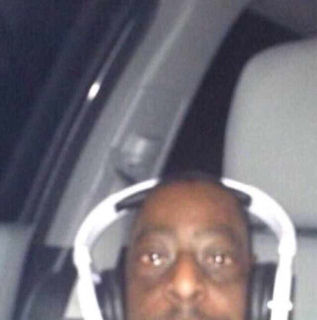 a man wearing headphones in the back seat of a car