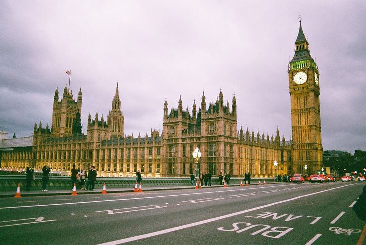 the big ben clock tower towering over the city of london in england, on a cloudy day