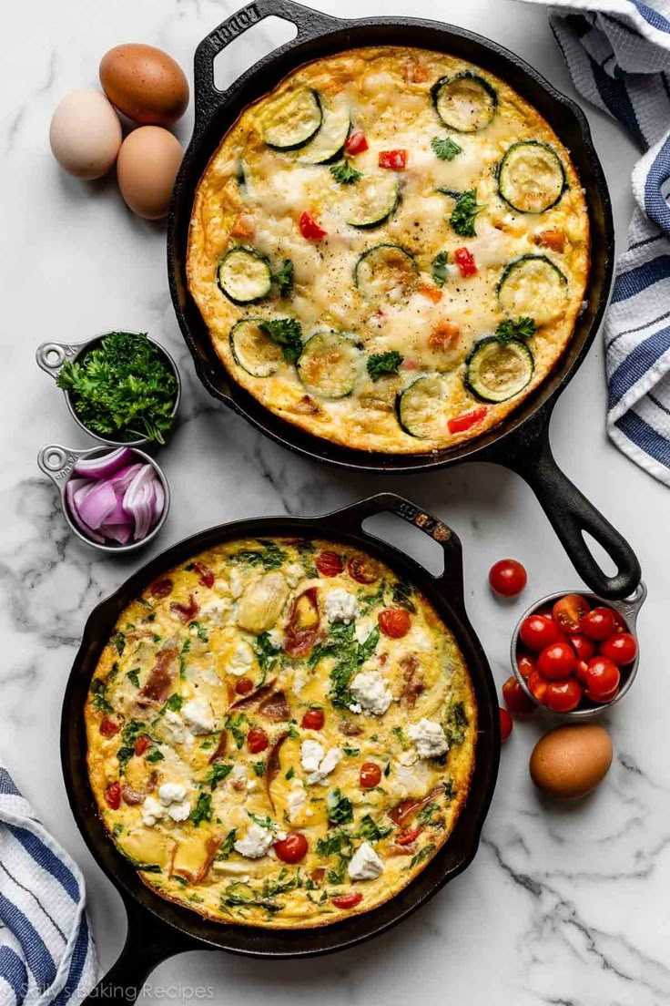 two pans filled with food sitting on top of a counter next to eggs and tomatoes