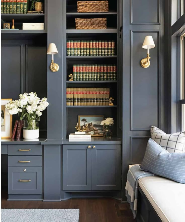 a living room filled with furniture and bookshelves covered in lots of bookcases