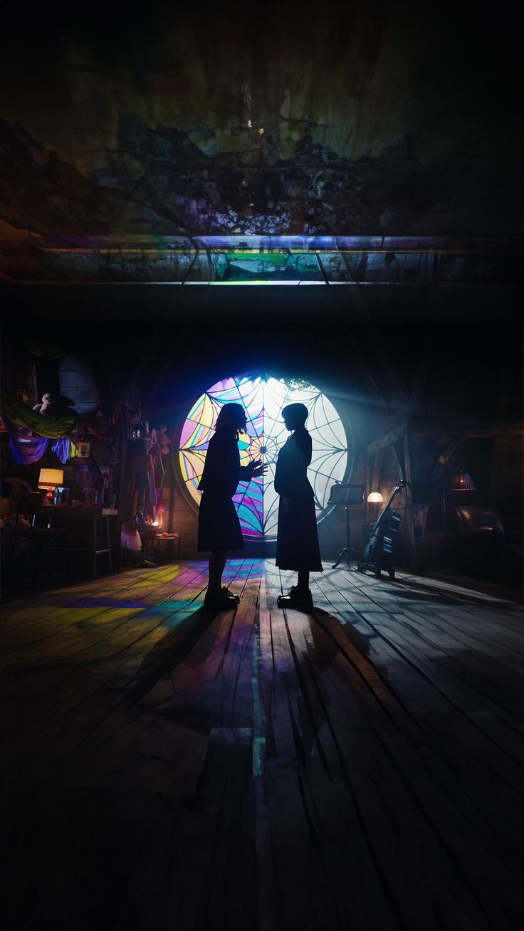 two people standing in front of a window with an umbrella projected on the wall behind them