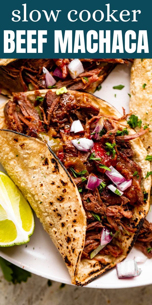 slow cooker beef tacos on a plate with cilantro and lime wedges