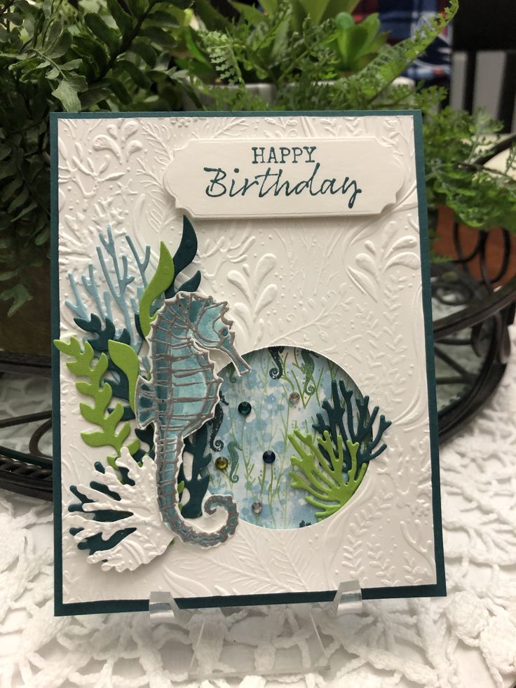 a card with an image of a seahorse on it and plants in the background