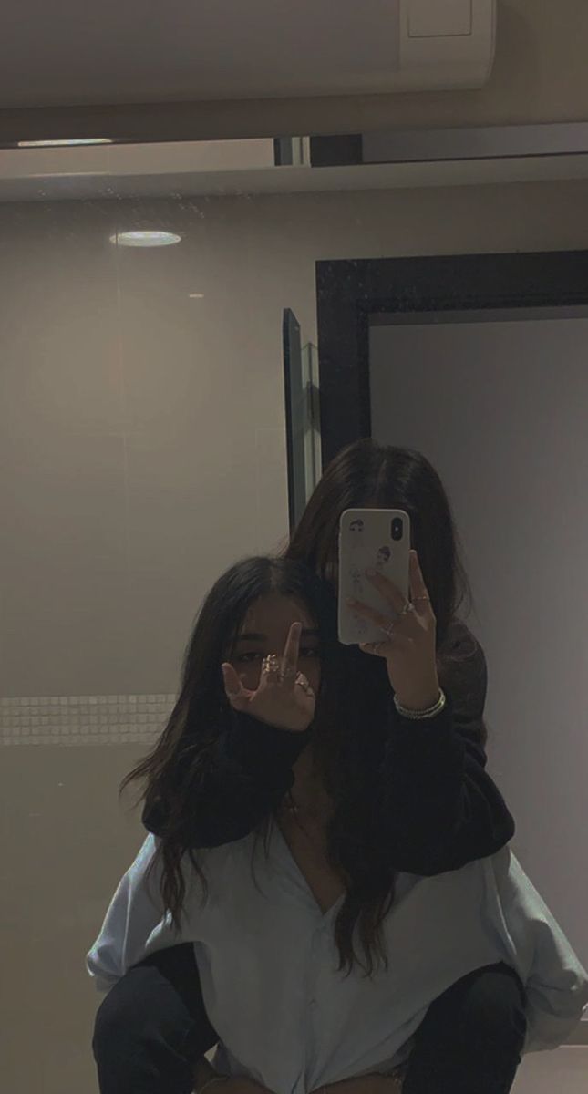 a woman taking a selfie in front of a mirror