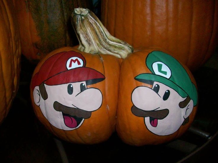 two pumpkins with mario and luigi painted on them