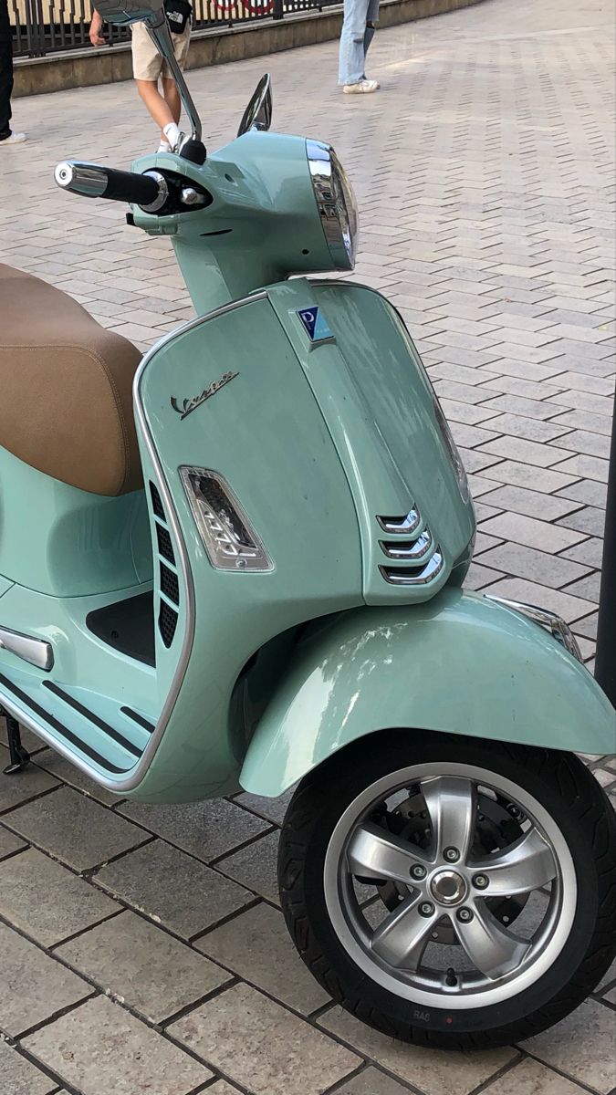 a blue scooter parked on the side of a street