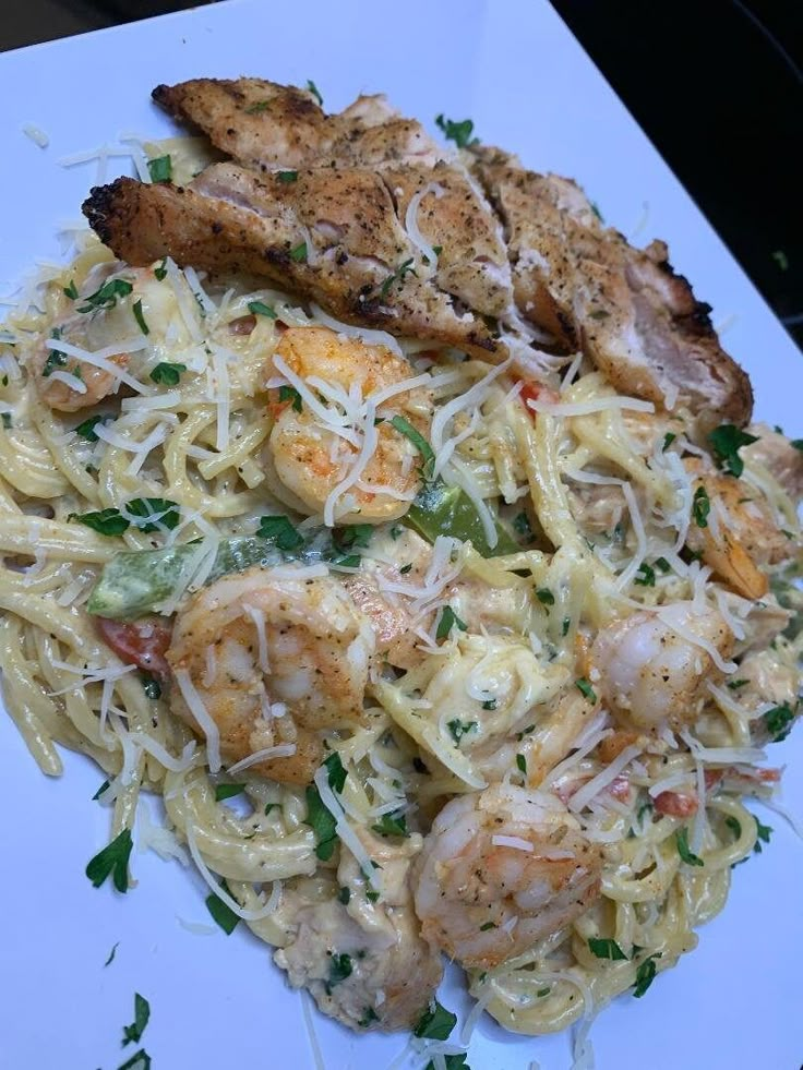 a white plate topped with pasta and shrimp