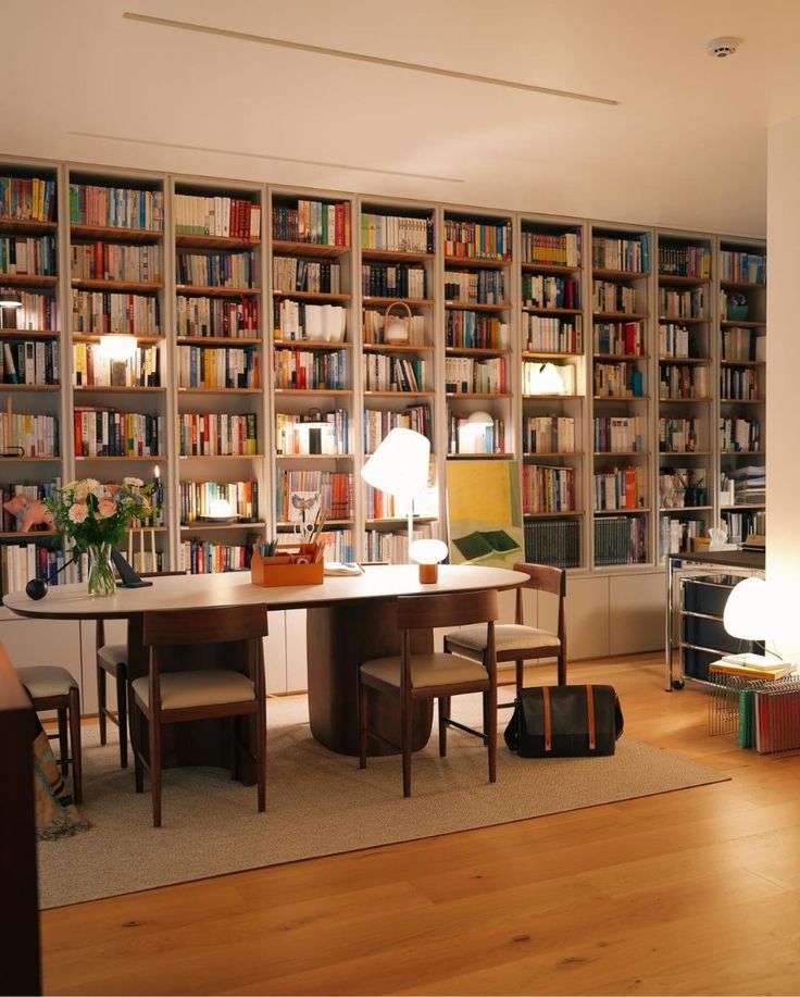 a living room filled with lots of books and furniture next to a book shelf full of books