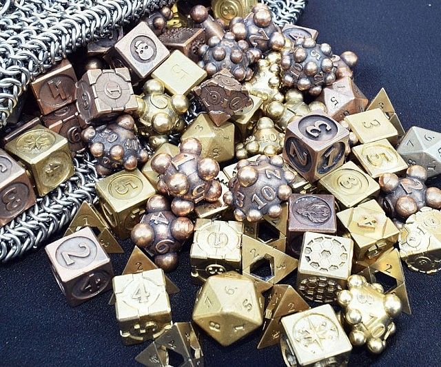 a pile of gold and silver dices sitting on top of a blue table cloth