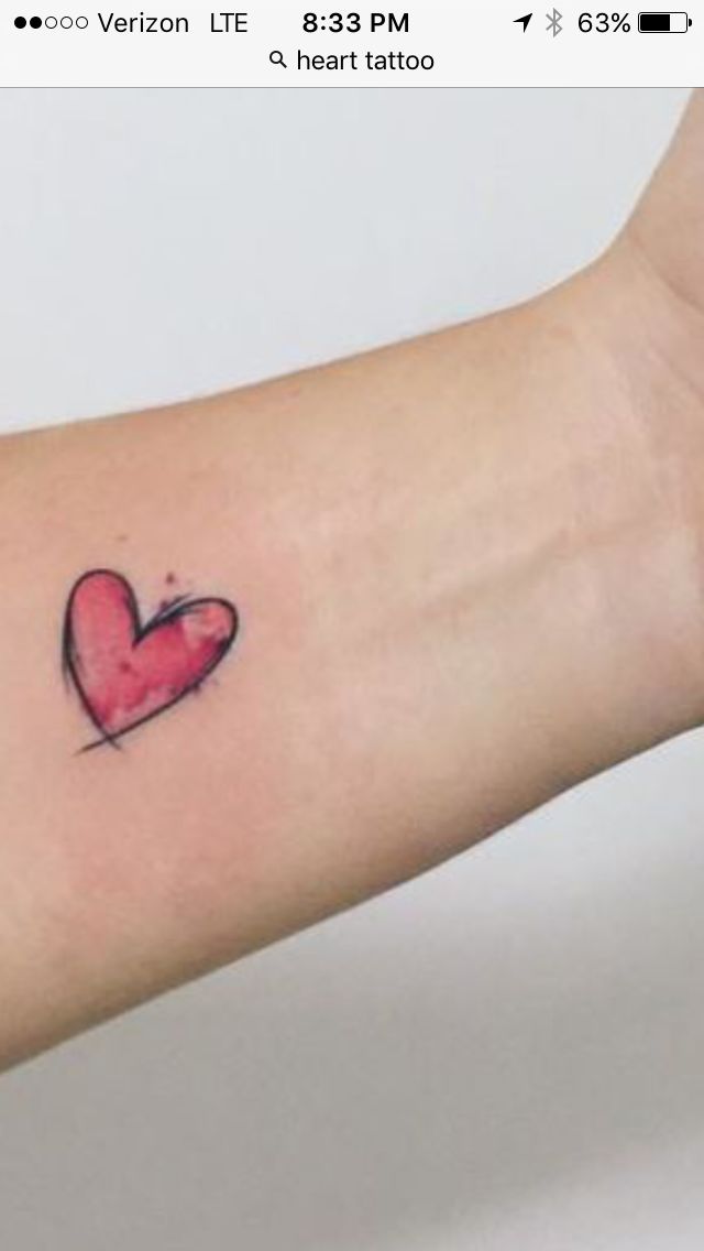 a small heart tattoo on the wrist