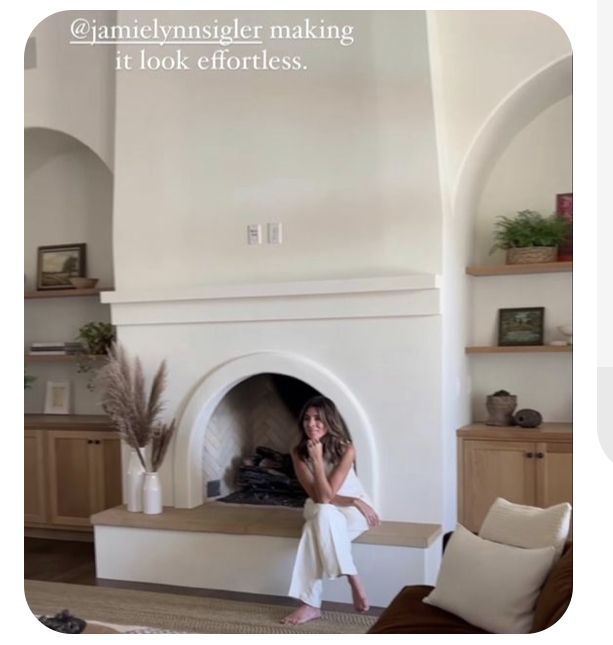 a woman sitting in front of a fire place