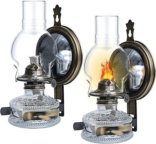 two antique style lamps with glass holders on each side and a flame in the middle