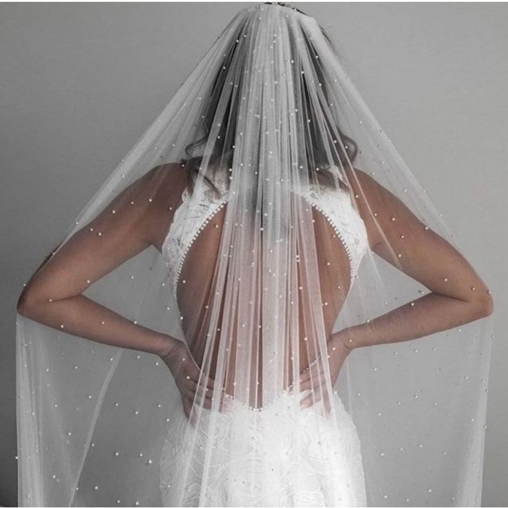 a woman in a wedding dress with a veil on her head and the back of her face