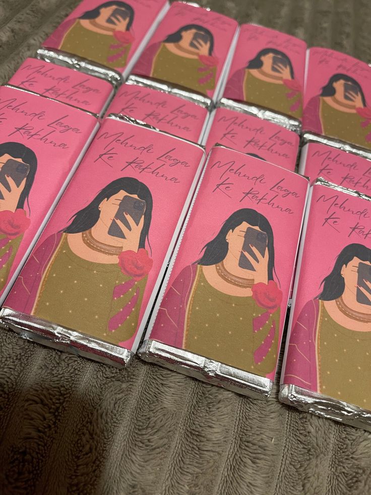 six pink lighters with pictures of women on them, all wrapped in tin foil