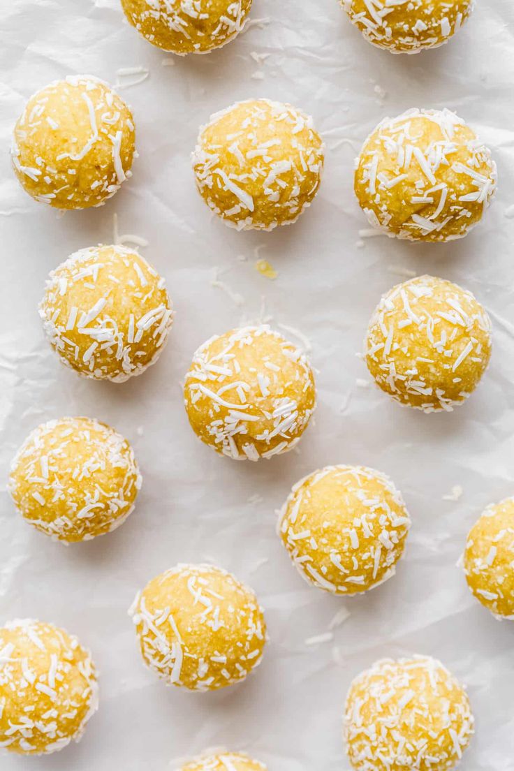 several lemon balls are lined up on a sheet of wax paper with white sprinkles