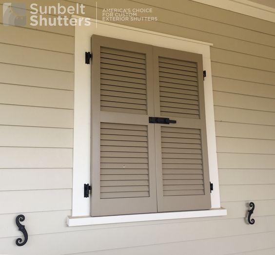 an open window with shutters on the side of a house