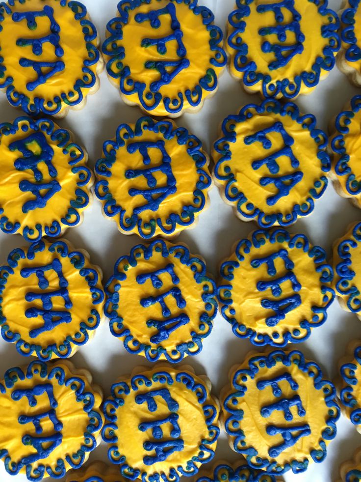 decorated cookies with blue and yellow icing in the shape of bitcoin symbols