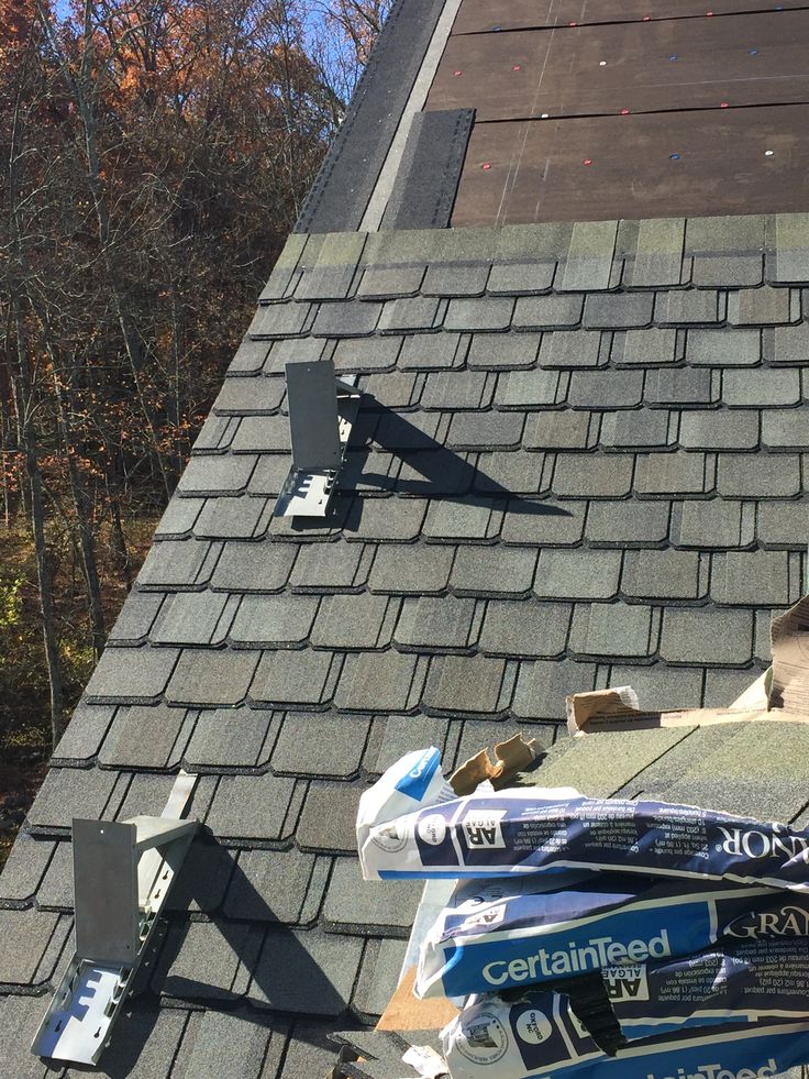 the roof of a house that has been gutted with new shingles and asphalt