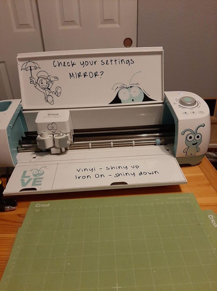 a cricut machine sitting on top of a wooden table next to a cutting board