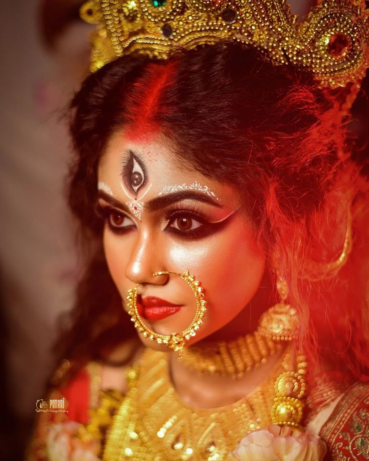 a woman with makeup on her face and gold jewelry