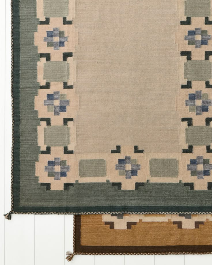 two rugs are hanging on the wall next to each other, one has a blue and beige design