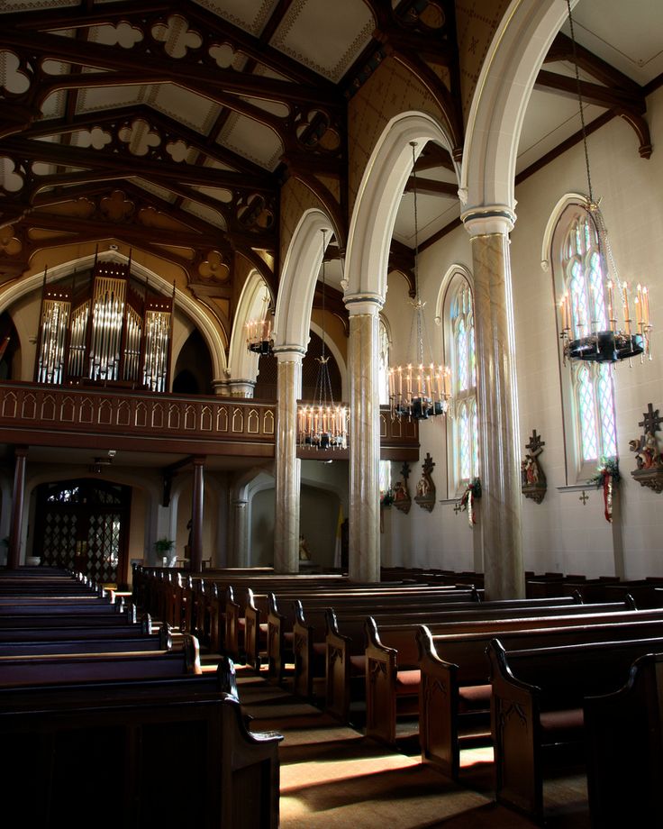 the inside of a church with pews and chandeliers