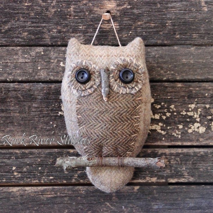 an owl statue hanging on the side of a wooden wall