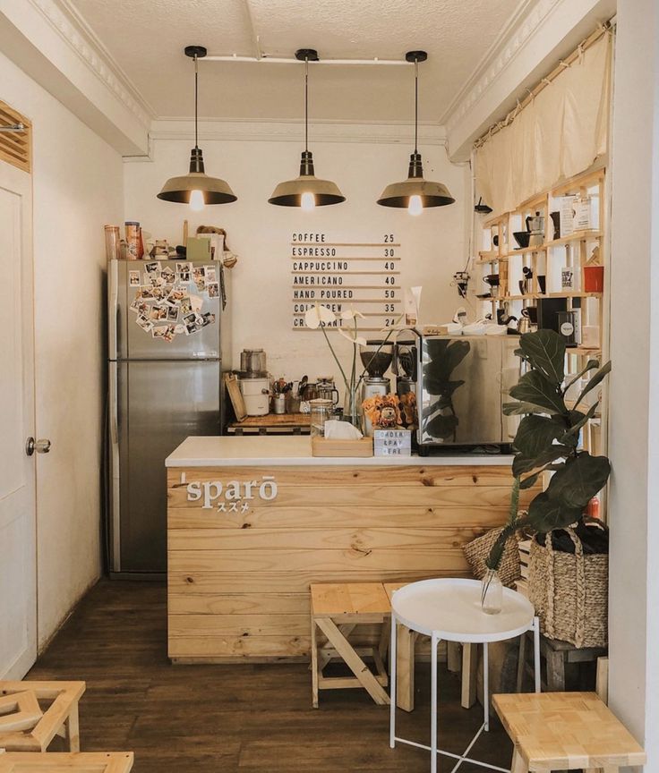 the interior of a coffee shop with wooden tables and stools