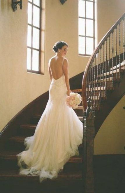 a woman in a wedding dress is walking down the stairs