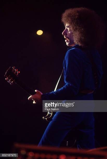 an image of a man playing guitar in the dark