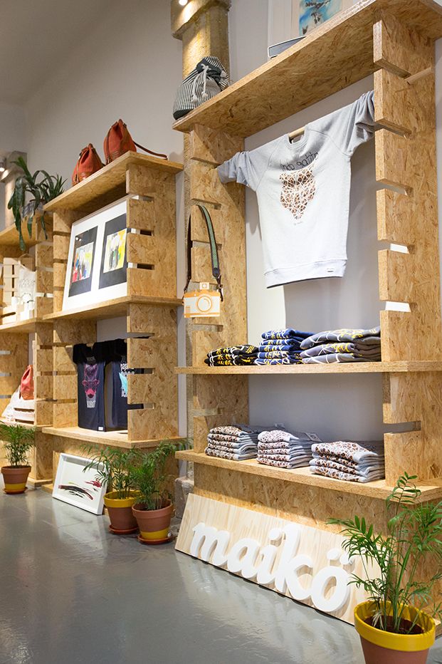 a store display with wooden shelves filled with items and plants on top of each shelf