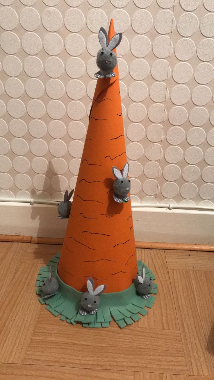 a paper hat with rabbits on it sitting on top of a wooden floor next to a wall