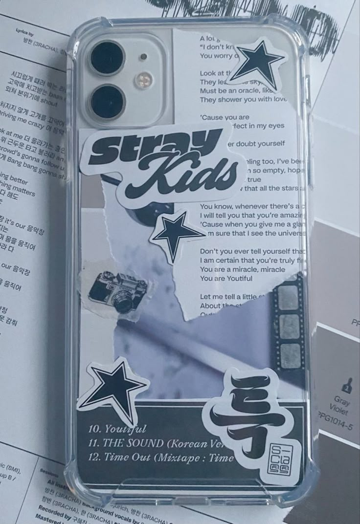 an iphone case with stickers on it sitting on top of some papers and paper