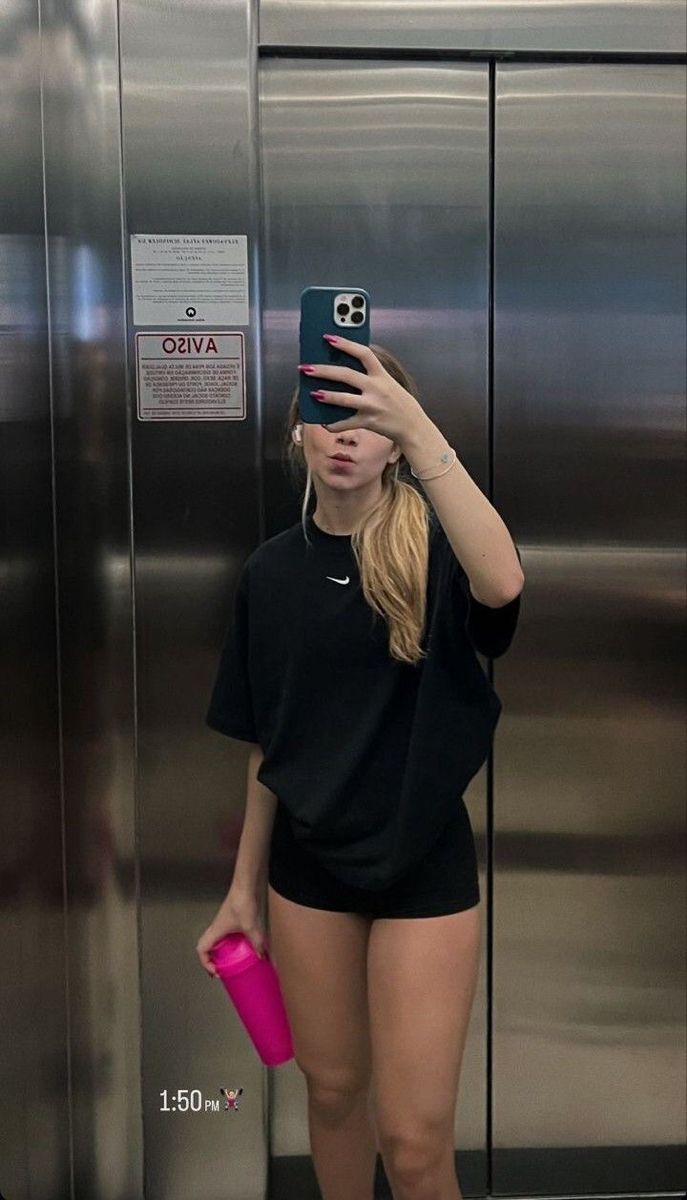 a woman taking a selfie in front of an elevator